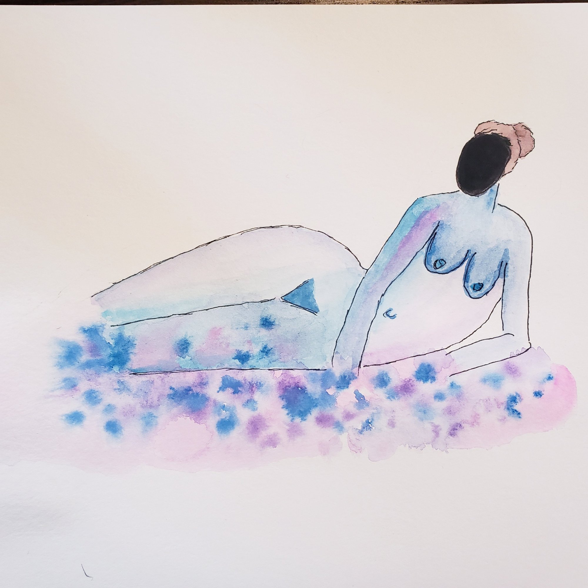 Prone woman in pastels with blackened out face